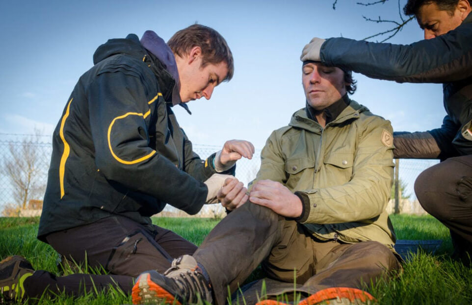 Wilderness rescue students checking for the patents pulse and for head injuries.