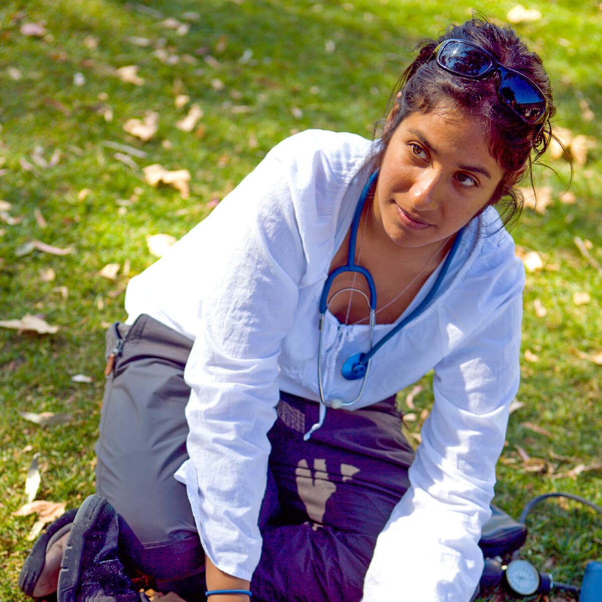 Wilderness rescue student with a stethoscope in the grass.